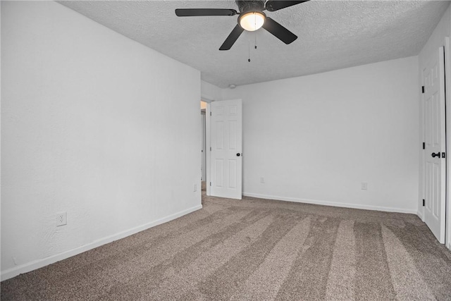 carpeted spare room featuring a ceiling fan, a textured ceiling, and baseboards