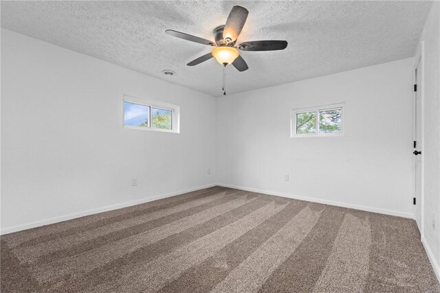 carpeted spare room with ceiling fan and a textured ceiling