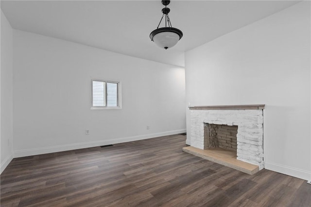 unfurnished living room with visible vents, a fireplace, baseboards, and wood finished floors