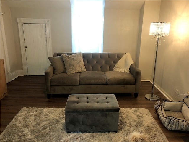 living room with dark hardwood / wood-style flooring and an inviting chandelier