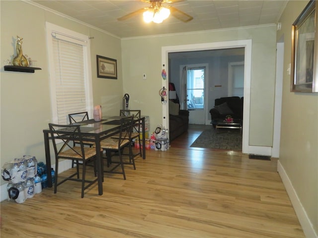 dining space with light hardwood / wood-style flooring, ceiling fan, and ornamental molding