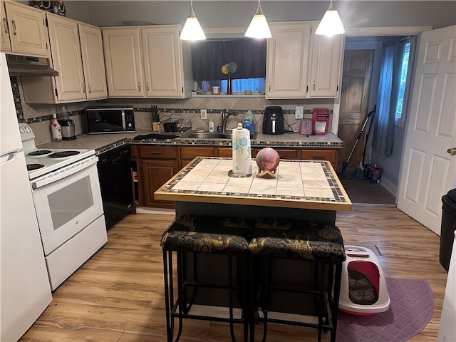 kitchen featuring light wood-type flooring, a center island, tasteful backsplash, and black dishwasher