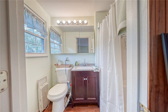 bathroom with hardwood / wood-style floors, vanity, and toilet