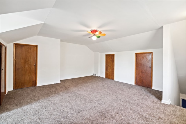 interior space featuring vaulted ceiling, ceiling fan, and carpet floors