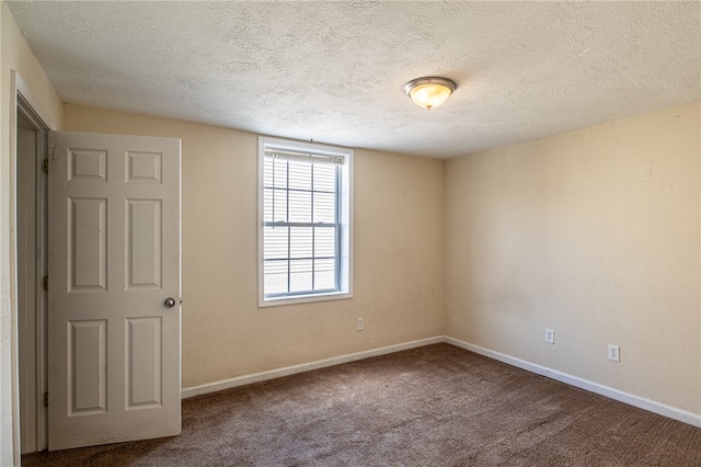 empty room with a textured ceiling and carpet