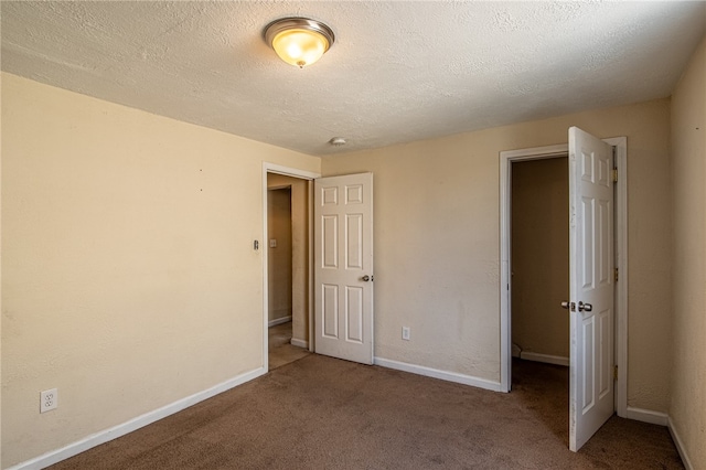 unfurnished bedroom featuring a textured ceiling and carpet floors