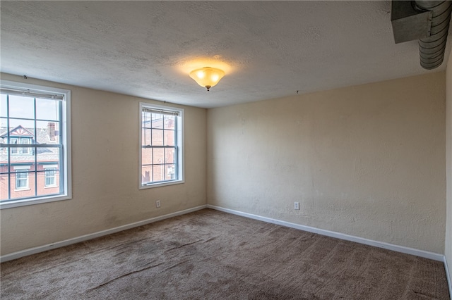 empty room with a textured ceiling and carpet flooring