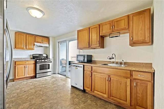 kitchen with a textured ceiling, stainless steel appliances, and sink