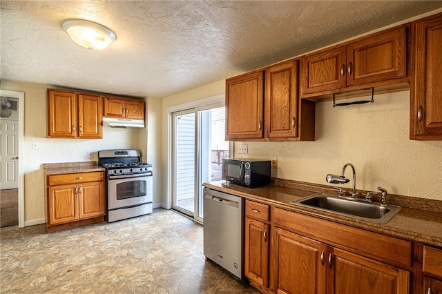 kitchen with appliances with stainless steel finishes, a textured ceiling, and sink