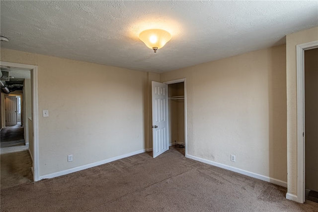 carpeted empty room featuring a textured ceiling