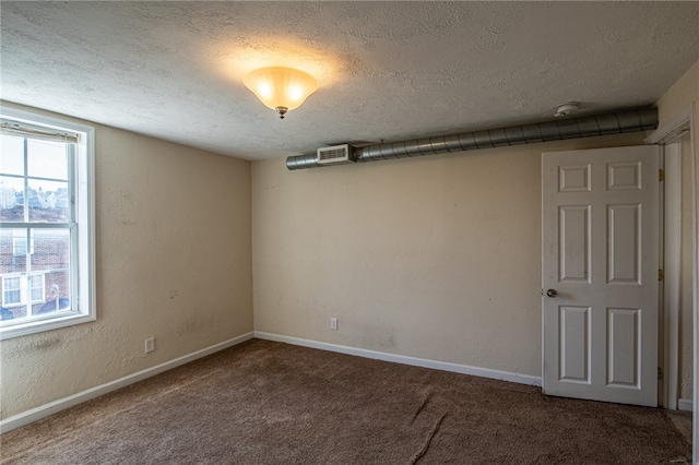 unfurnished room with a textured ceiling and carpet flooring