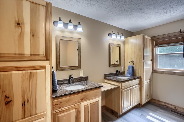 bathroom with vanity, hardwood / wood-style flooring, and a textured ceiling