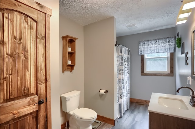 bathroom with toilet, vanity, hardwood / wood-style flooring, a textured ceiling, and a shower with shower curtain