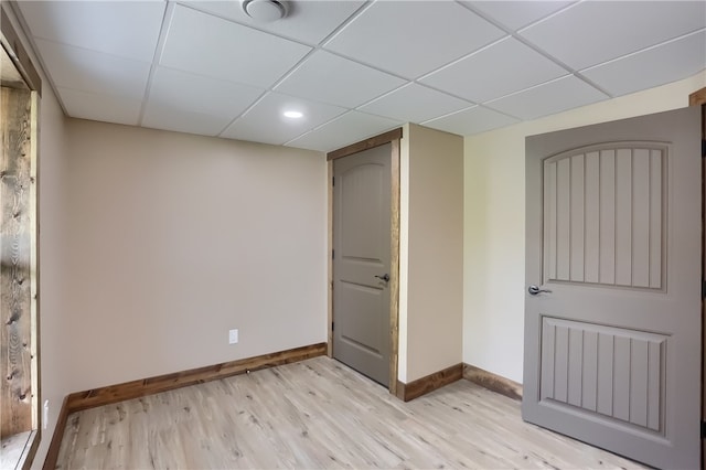 basement featuring light hardwood / wood-style flooring and a drop ceiling