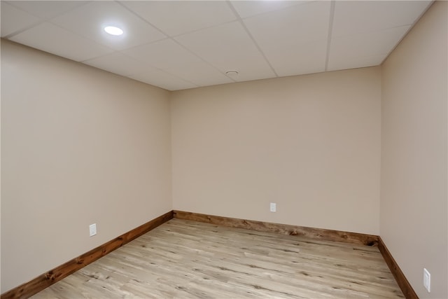 unfurnished room featuring light hardwood / wood-style flooring and a paneled ceiling