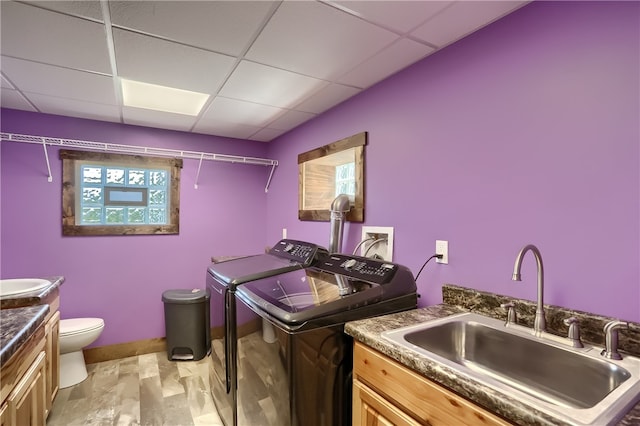 laundry area with separate washer and dryer and sink