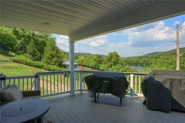 wooden terrace with grilling area and a water view