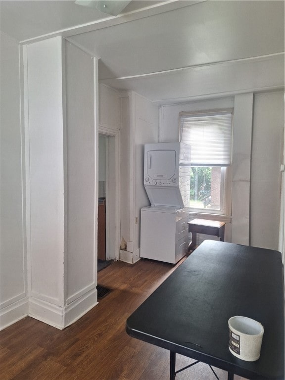 kitchen with stacked washing maching and dryer and dark hardwood / wood-style floors