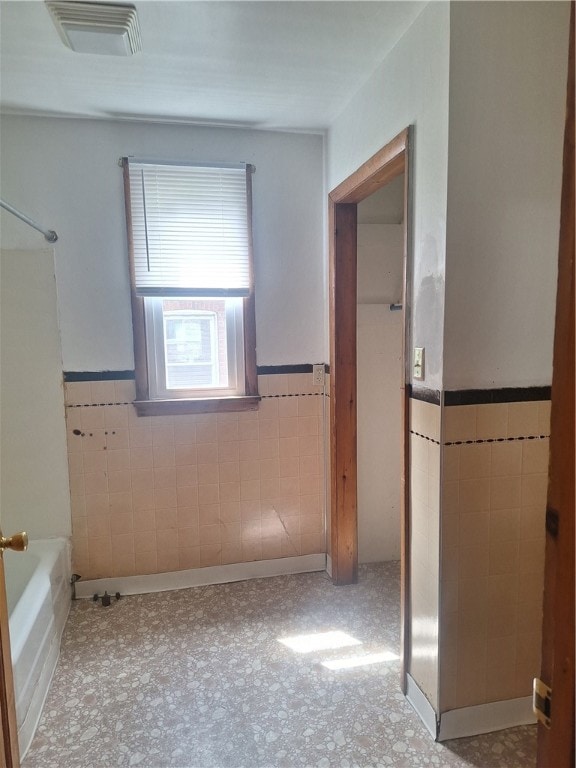 bathroom featuring tile walls and shower / washtub combination