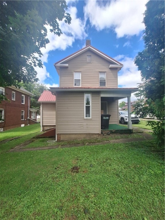 rear view of property with a lawn