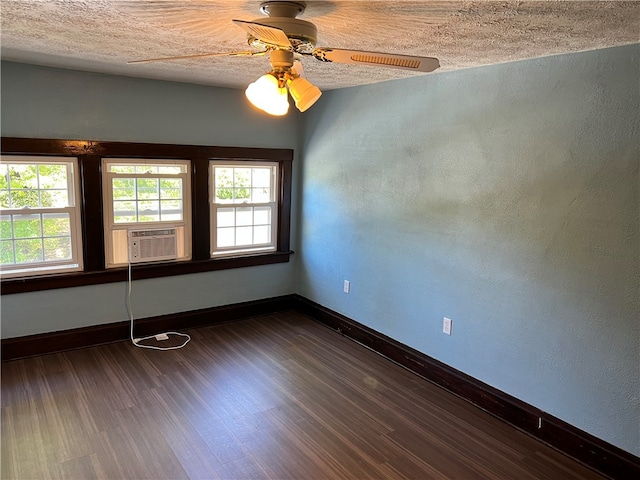 empty room with cooling unit, ceiling fan, dark hardwood / wood-style floors, and a textured ceiling