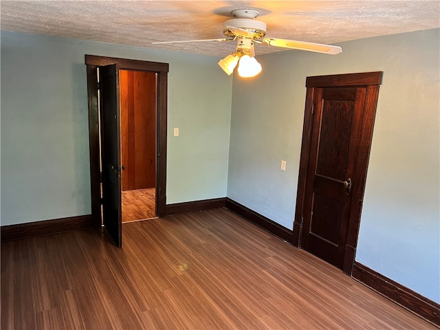 spare room featuring a textured ceiling, ceiling fan, and dark hardwood / wood-style floors