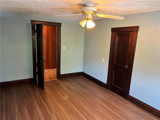 empty room featuring ceiling fan, a textured ceiling, baseboards, and wood finished floors