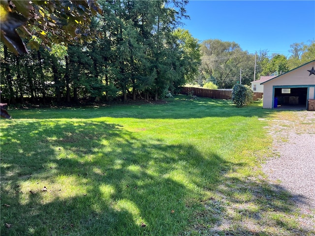 view of yard with a garage and an outbuilding