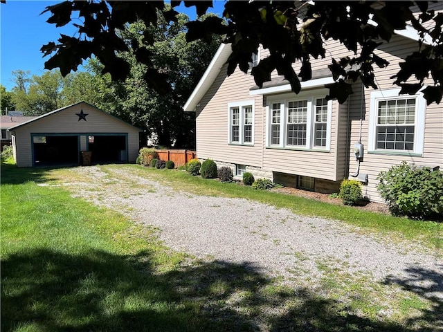 view of side of property featuring a lawn, an outdoor structure, fence, and a detached garage