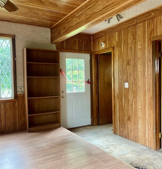 entryway with wooden ceiling, hardwood / wood-style floors, ceiling fan, and wooden walls