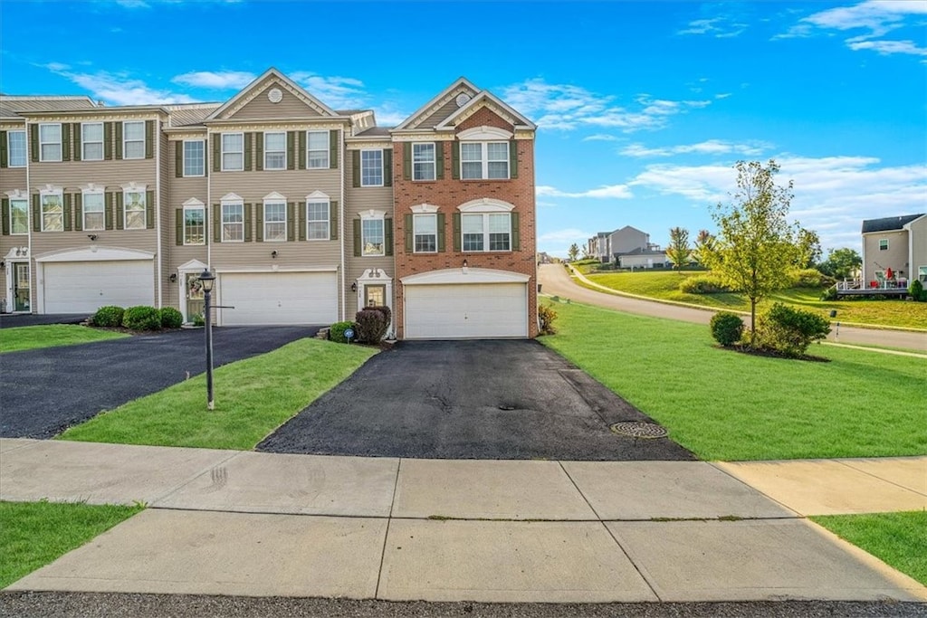 townhome / multi-family property featuring a front lawn and a garage