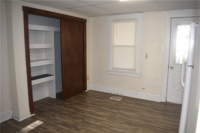 unfurnished bedroom with a closet and dark hardwood / wood-style floors