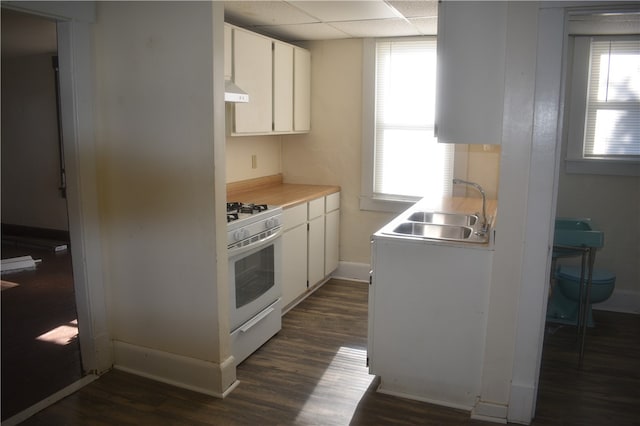 kitchen featuring dark wood-type flooring, white gas stove, sink, white cabinetry, and a paneled ceiling