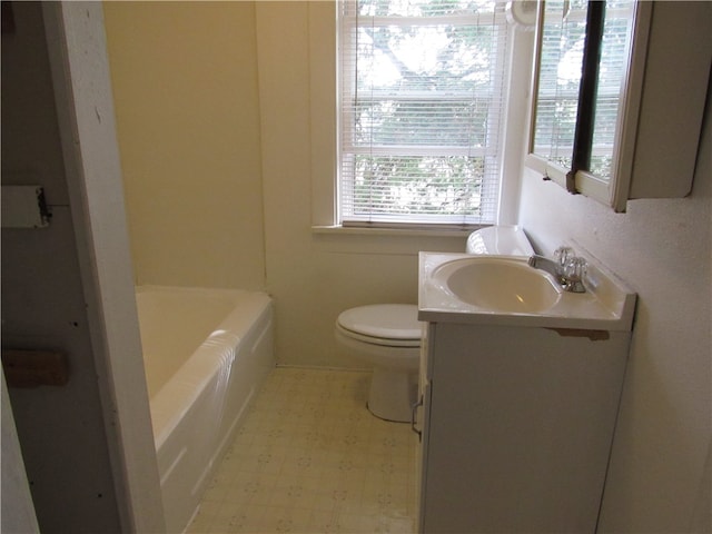 bathroom featuring a tub to relax in, toilet, and vanity