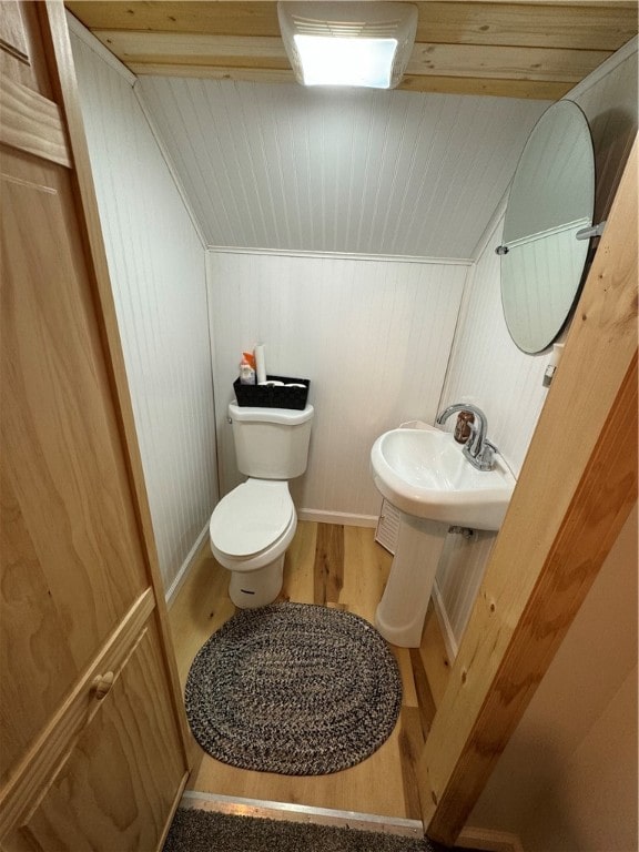 bathroom featuring vaulted ceiling, wood-type flooring, wood ceiling, toilet, and wooden walls