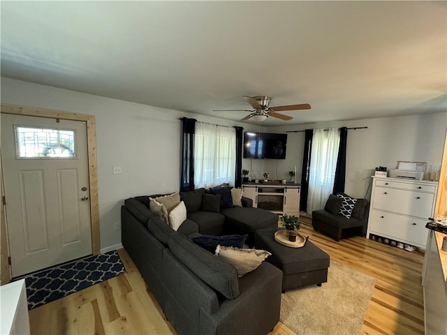 living room with light hardwood / wood-style flooring and ceiling fan