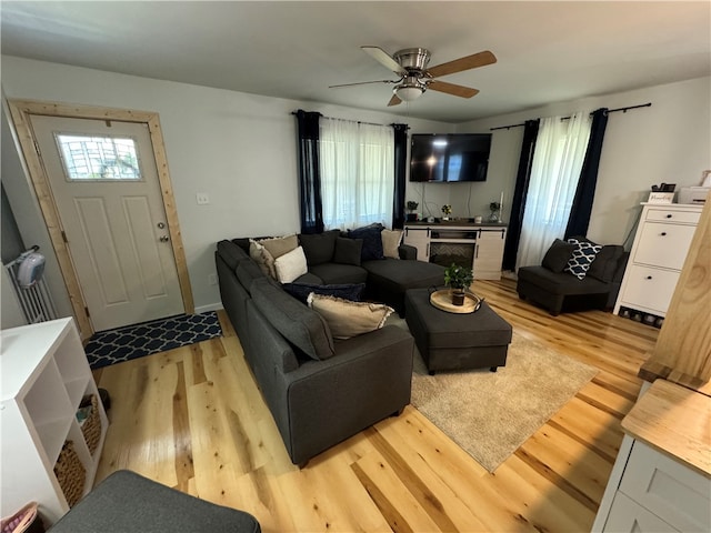 living room with ceiling fan and light hardwood / wood-style flooring