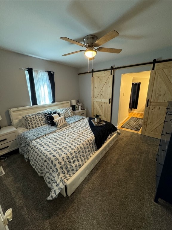 bedroom featuring ceiling fan, a barn door, and carpet floors