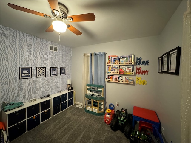 recreation room featuring dark carpet and ceiling fan