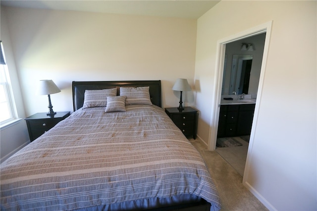 bedroom featuring connected bathroom, sink, and carpet floors