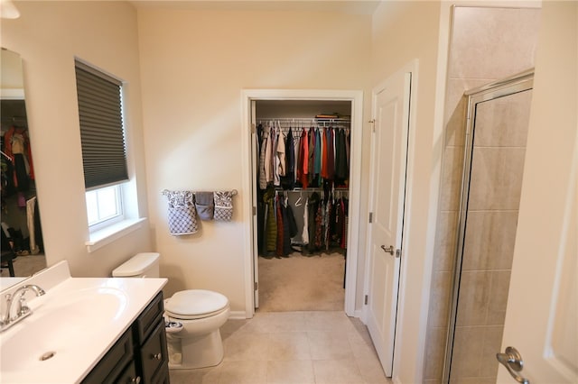 bathroom with tile patterned floors, toilet, a shower with door, and vanity