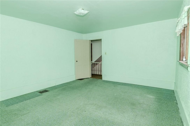 empty room featuring visible vents and carpet