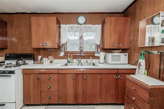 kitchen with wood walls, white appliances, and sink