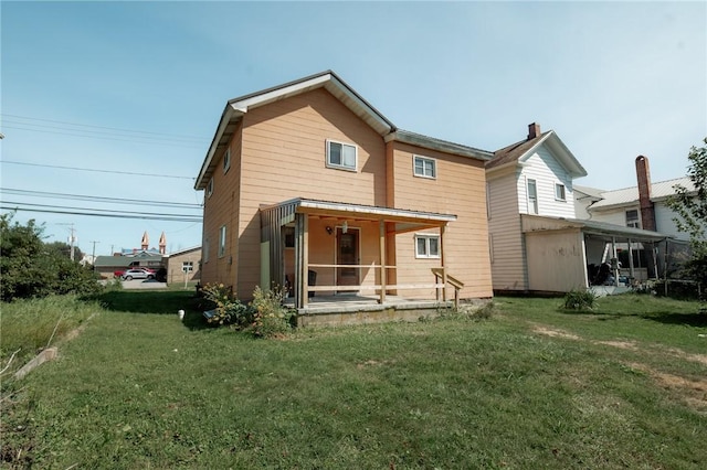 rear view of property with a yard and a sunroom
