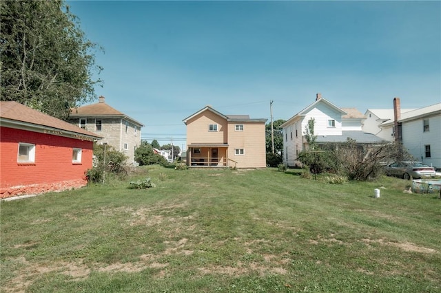 rear view of property featuring a lawn