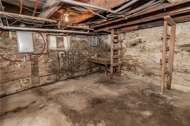 basement featuring electric panel and tankless water heater