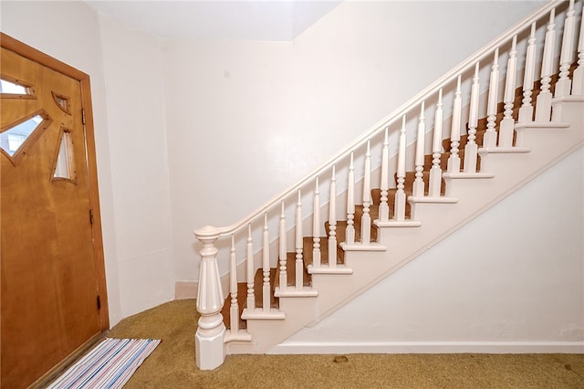 staircase featuring carpet