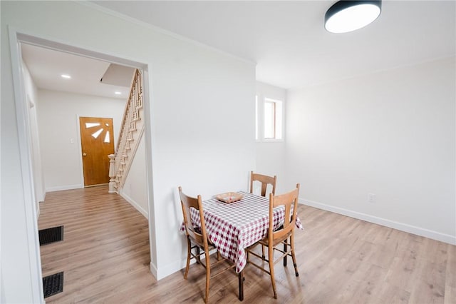 dining space with baseboards, visible vents, and wood finished floors