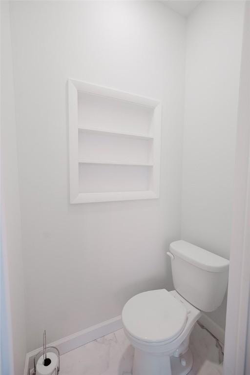 bathroom featuring baseboards, marble finish floor, and toilet