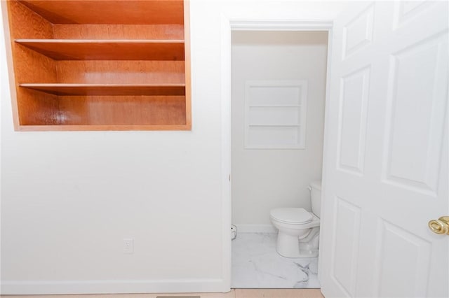 bathroom featuring baseboards, toilet, and marble finish floor